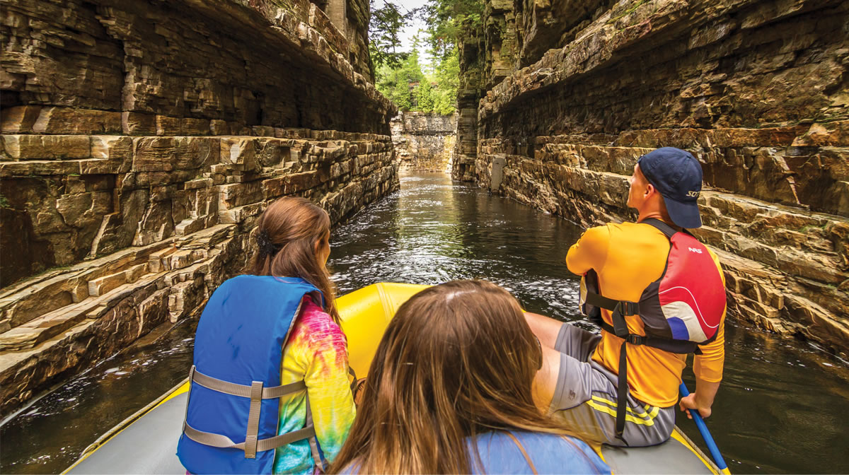 Three people rafting in Ausable Chasm